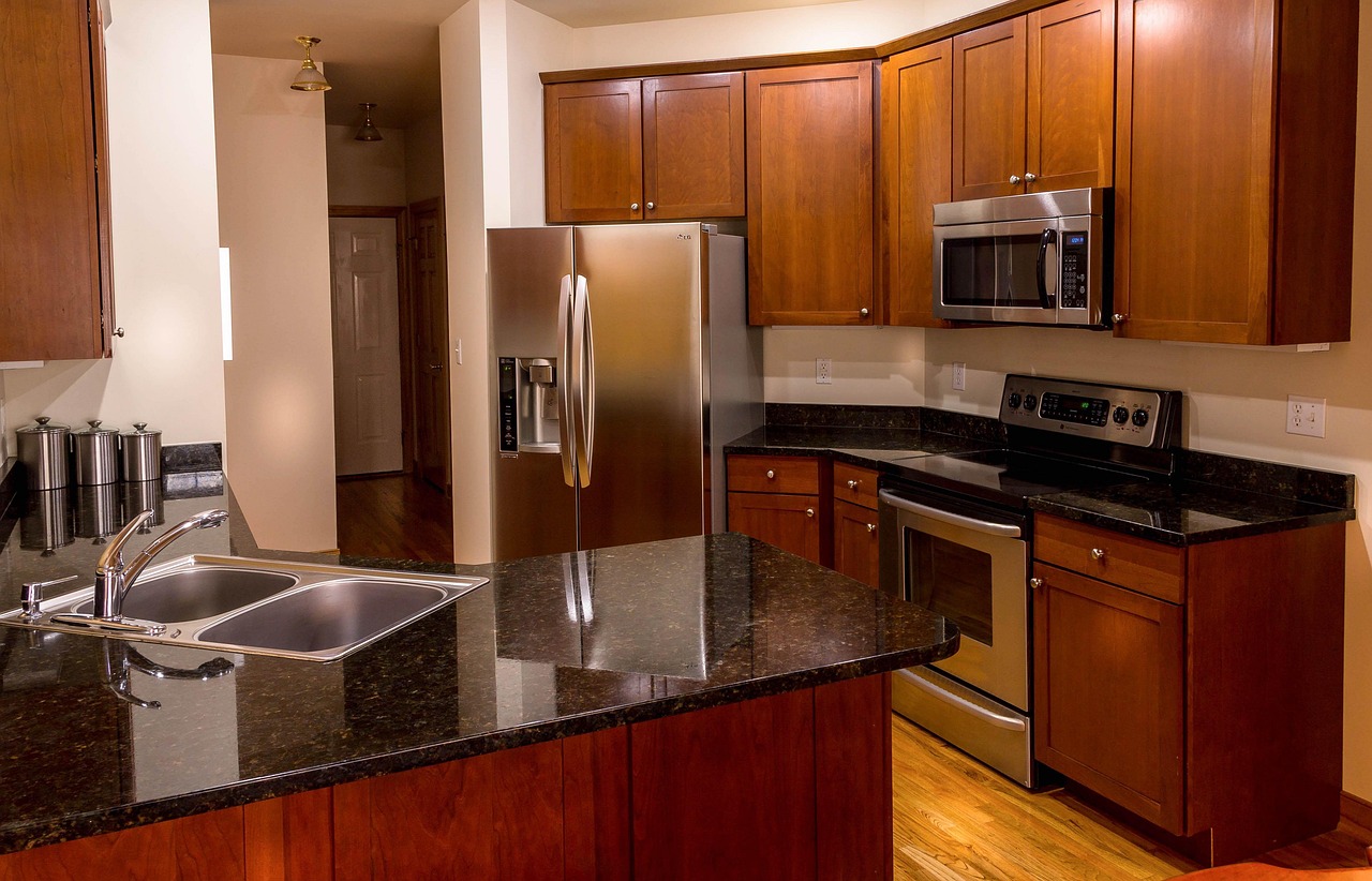 Modern kitchen with granite countertops and cabinetry above the stove and range