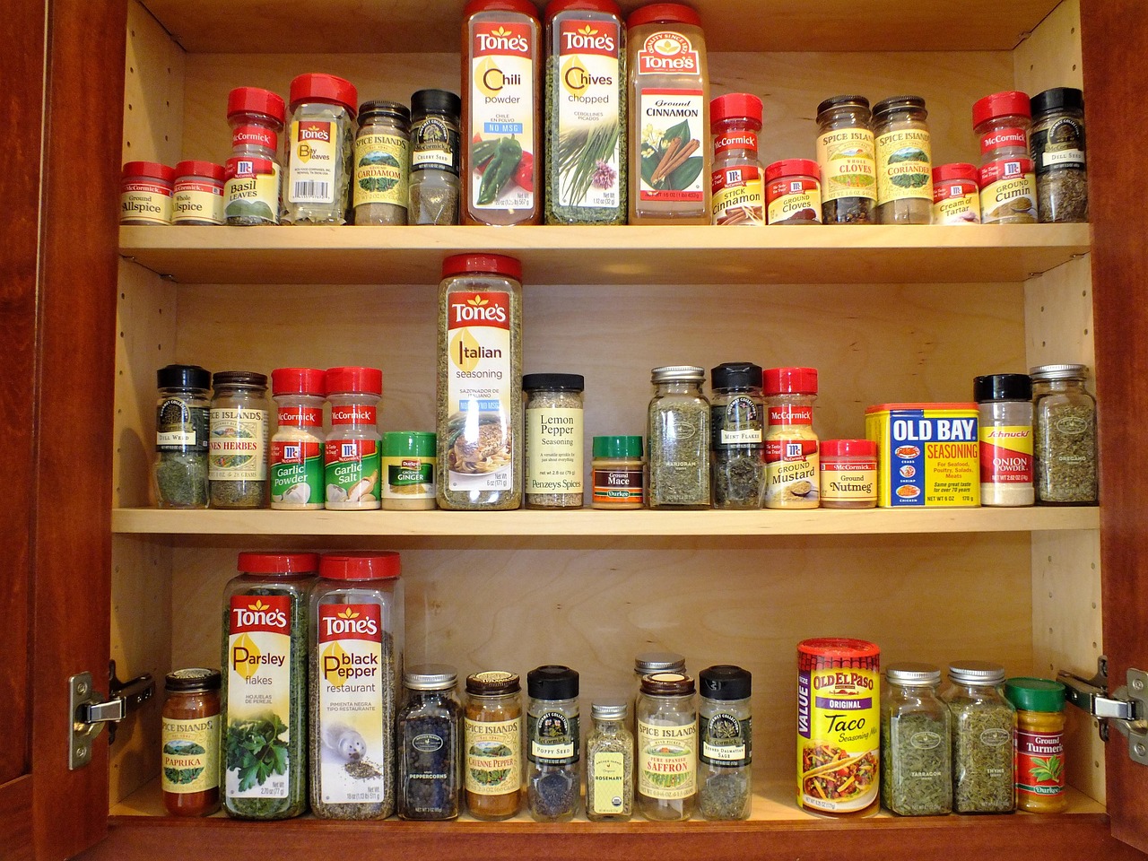 Neatly organized spice cabinet with labeled jars in rows