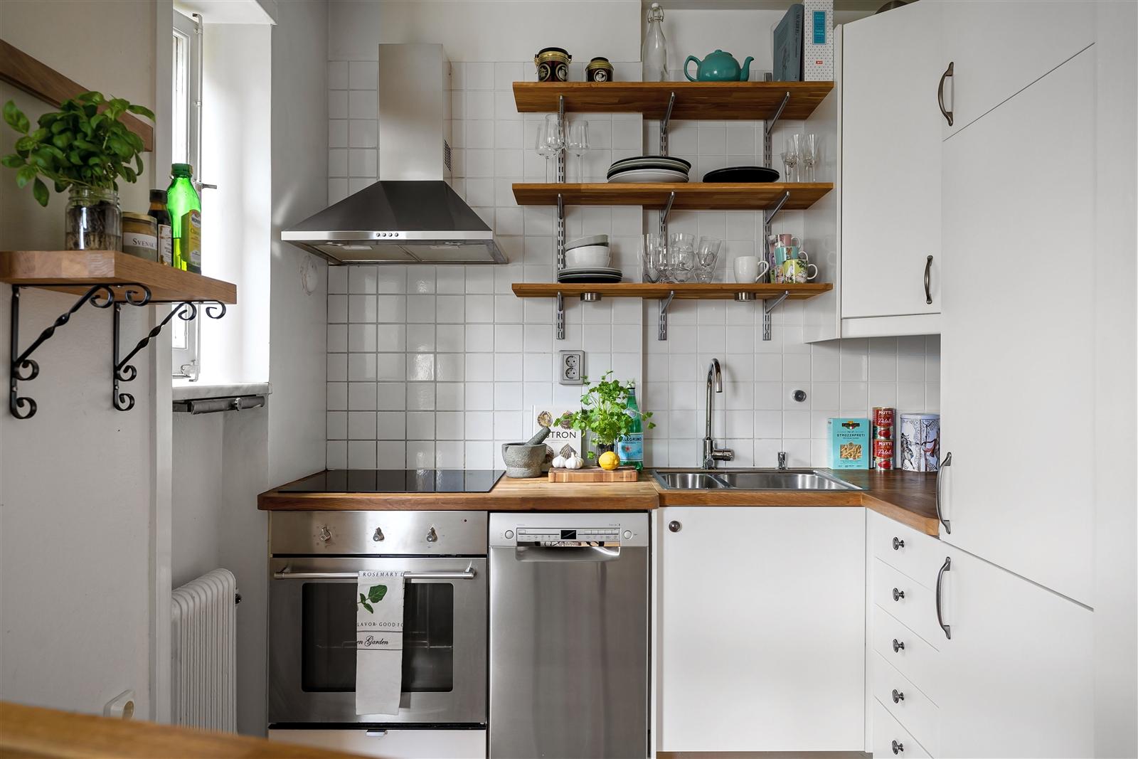 Modern white kitchen with organized open shelving and stainless steel appliances