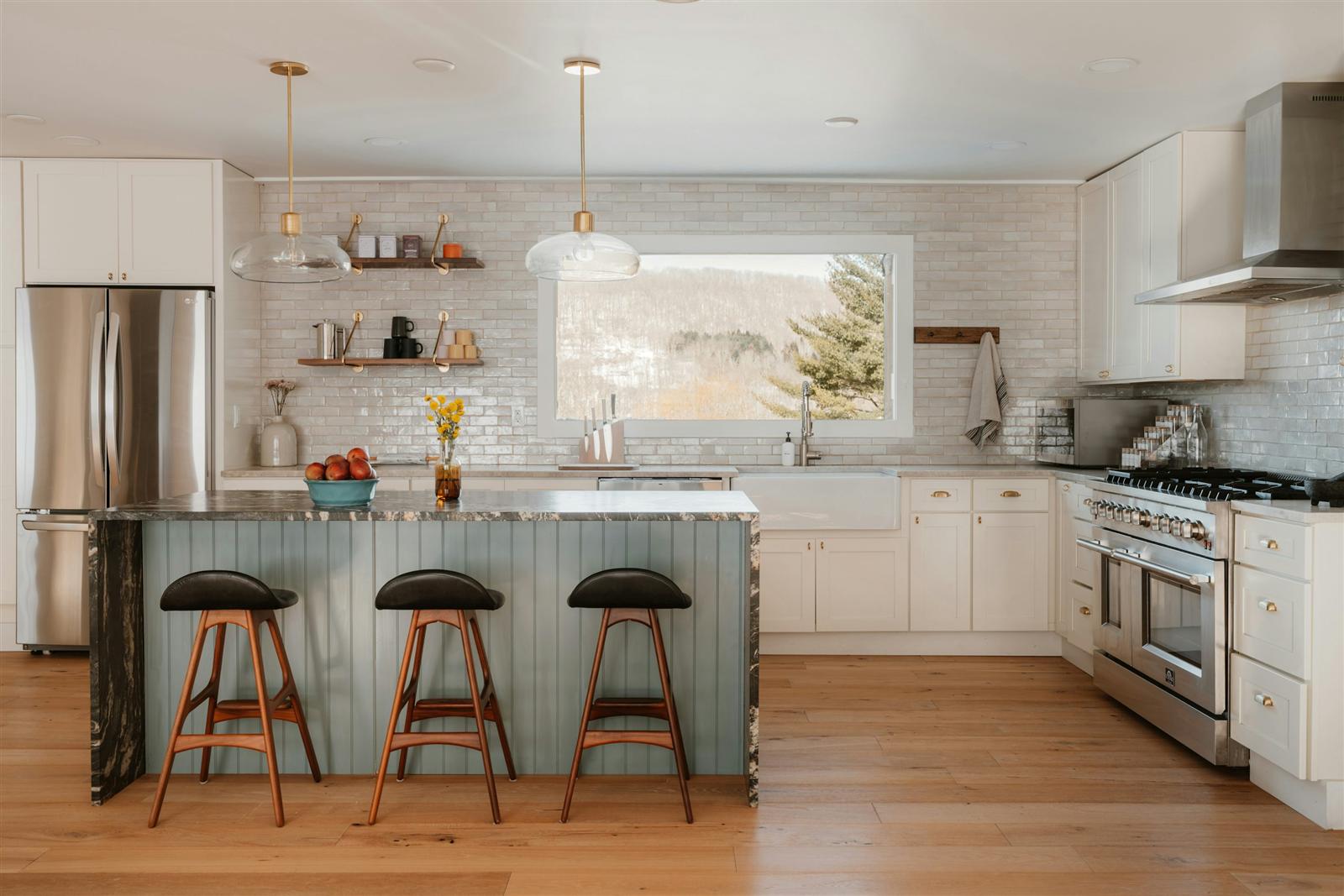 A modern kitchen island with stainless steel appliances and clear walkway space on both sides