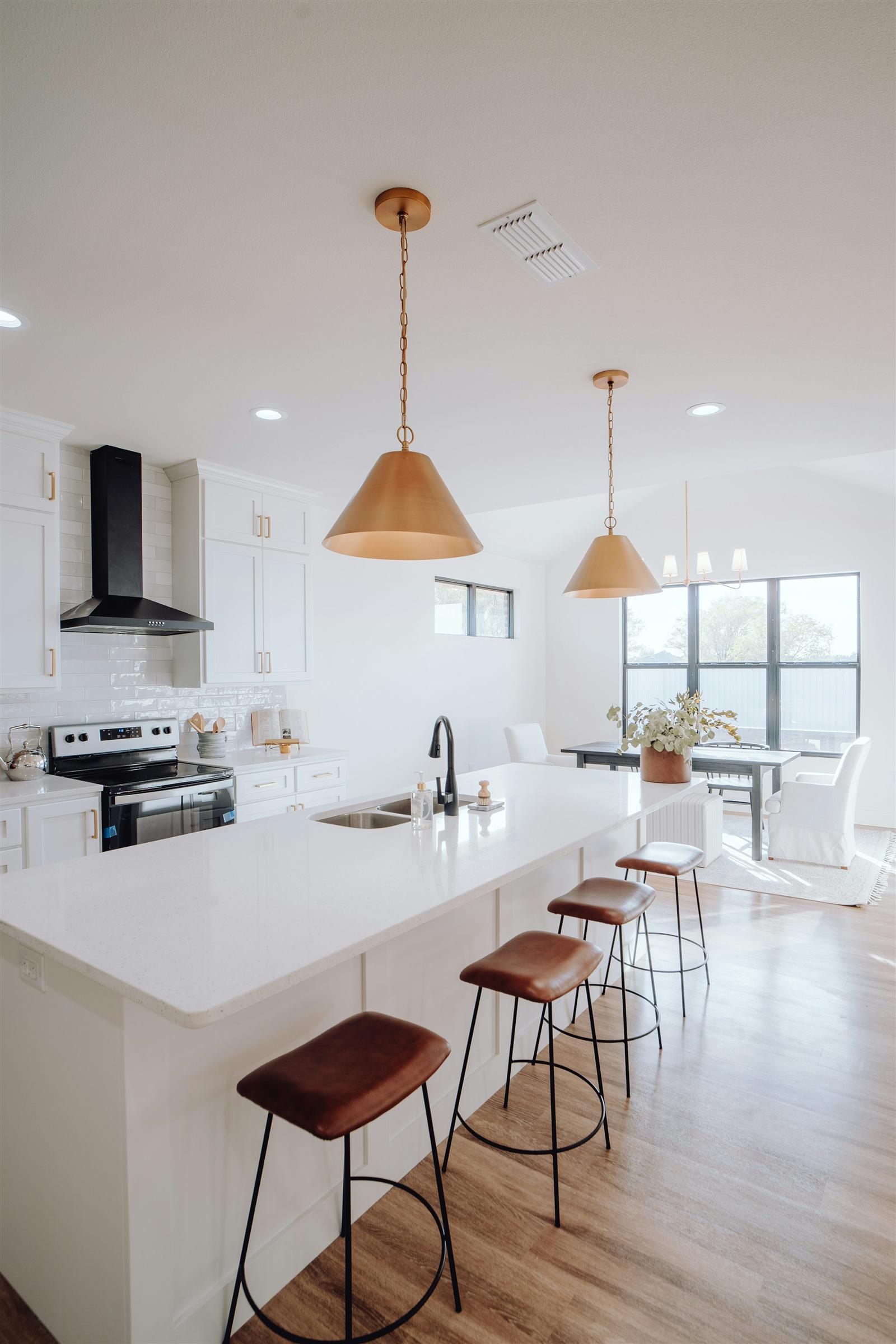 A large kitchen with a spacious center island and bar stool seating in an open floor plan