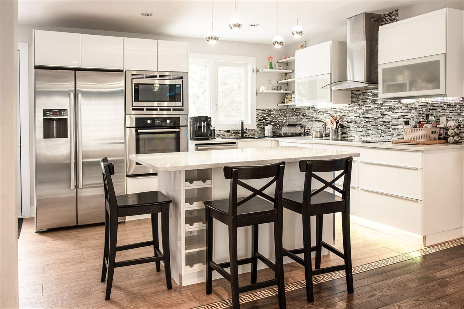 Bright white kitchen with island seating and stainless appliances, the kind of neutral design that appeals broadly to buyers